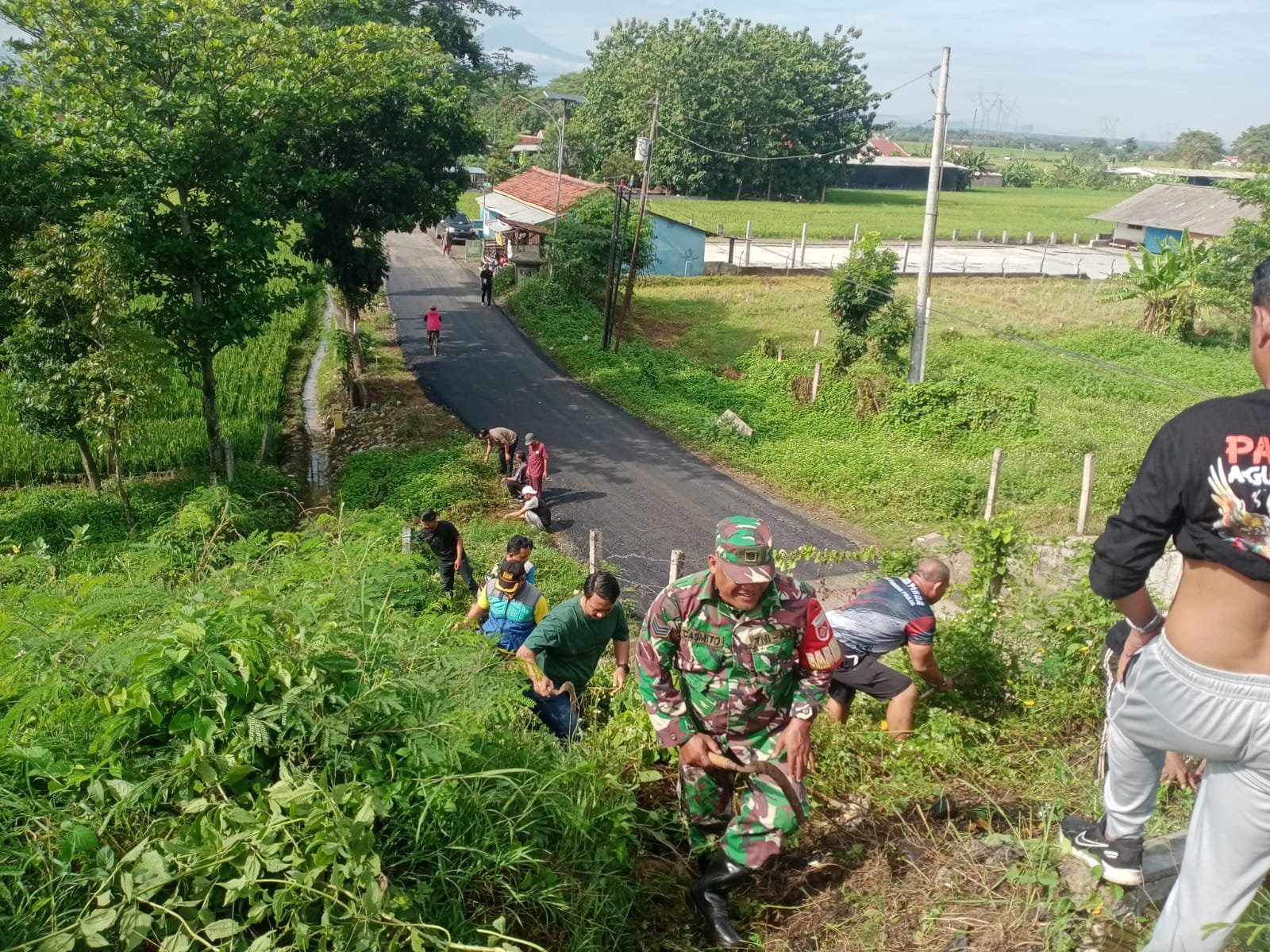 Pelopor Dalam Kemanunggalan TNI dan Rakyat, Babinsa Sitemu Ajak Masyarakat Bersihkan Lingkungan di Bahu Jalan Tol